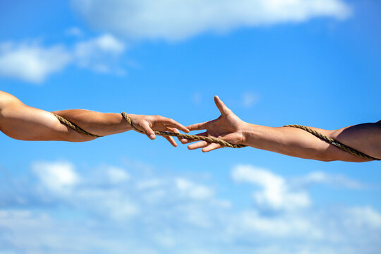 Rope, cord. Hand holding a rope, climbing rope. Hand holds the rope and helps the person escape. Two hands, helping hand of a friend. Rescue, help, helping gesture or hands