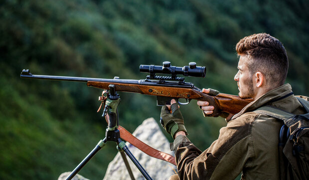 Hunting period. Hunter is aiming. The man is on the hunt. Hunter with shotgun gun on hunt. Deer hunt. Hunter in camouflage clothes ready to hunt with hunting rifle. Hunter man