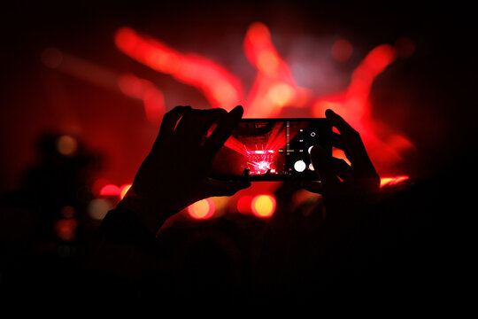 Cheering Crowd with Raised Hands at Vibrant Red Music Concert