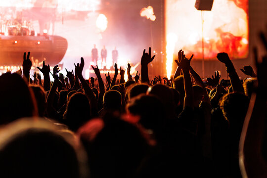 Audience Cheering with Raised Hands at Live Stage Concert