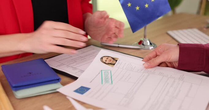 Woman consul informs client about approval of visa application. Specialist congratulates visitor after announcing successful EU visa approval