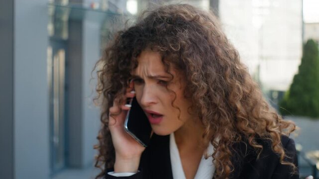 Irritated furious Caucasian business woman arguing angry talking mobile phone work conflict walking outdoor annoyed businesswoman female girl consultant argue talk smartphone dissatisfied walk in city