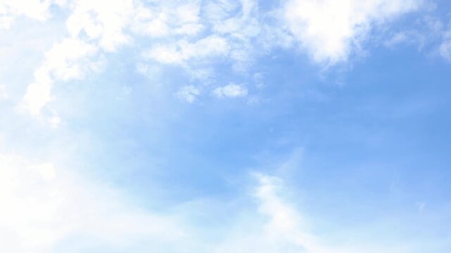 A 4K timelapse video showing a bright blue sky with white clouds slowly moving across.