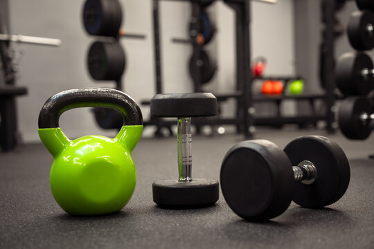 Dumbbells and kettlebells arranged in a modern gym, highlighting strength training equipment used for fitness, bodybuilding, endurance, and functional workout routines.