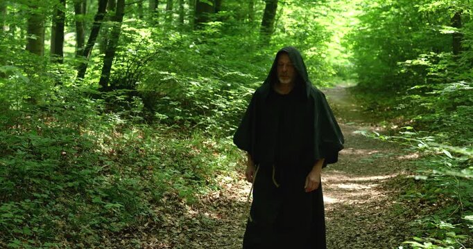 Religious monk makes a walking pilgrimage through the forest preserving traditions of solitude faith and spiritual practice.