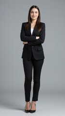 Obraz premium A confident businesswoman posing in professional office wear with her hands on her hips.