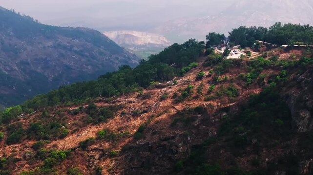 clouds shadow passing on Hills with trees, haze and parking area at nandi hills, Bangalore, karnataka, india. day time, stable shot, drone shot, 4k.
