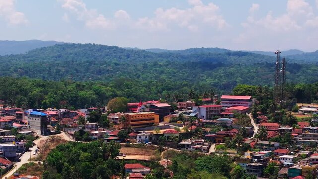 Aerial view of suntikoppa village with signal tower, western ghats and tropical forest at Madikeri, coorg, karnataka, india. day time, semi circle shot, drone shot, 4k.