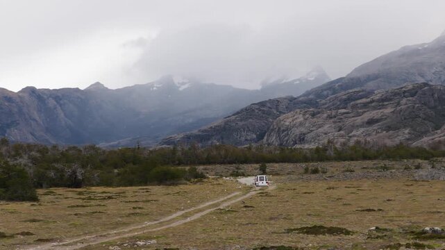 4x4 vehicle traveling near R&iacute;o de las Vueltas and El Chalt&eacute;n, Santa Cruz, Argentina, featuring glacially sculpted valleys, granite foothills, and cloud covered peaks of the Fitz Roy region drone track
