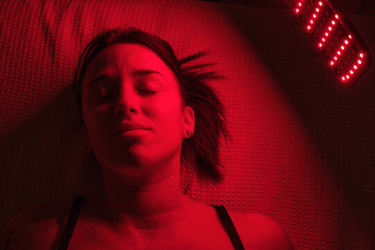 A woman receiving red light therapy for skincare whilst resting