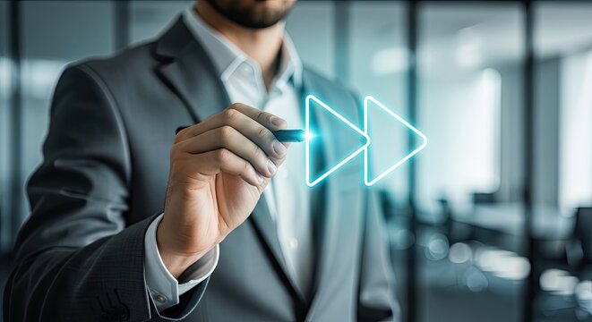 Businessman drawing fast forward icon with neon glow in office for digital acceleration concept