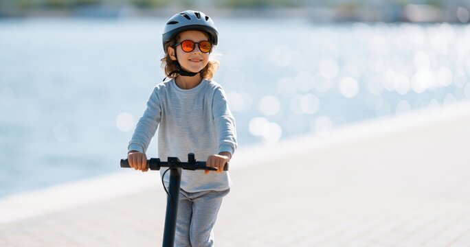 Child riding electric scooter outdoors