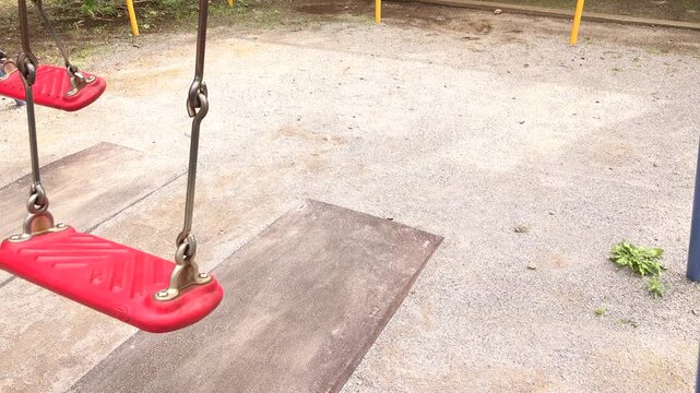 Moving red swing seat with copy space in a small Japanese park