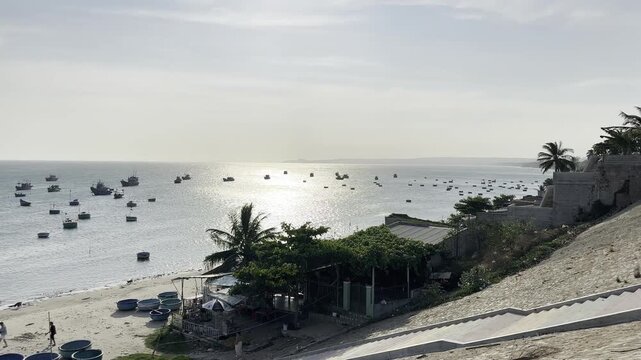 A sweeping panoramic video of a coastal fishing harbor filled with numerous round basket boats under soft afternoon light, showcasing the serene and authentic atmosphere of a traditional village.