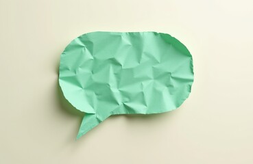 Obraz premium Green crumpled paper speech bubble isolated on light background. Empty conversation cloud for text messages and communication ideas. Simple design element.