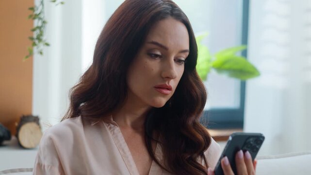 Caucasian woman girl business female using mobile phone reading bad content post in social media spam error internet problem lose wi-fi feeling upset at home businesswoman with smartphone dissatisfied