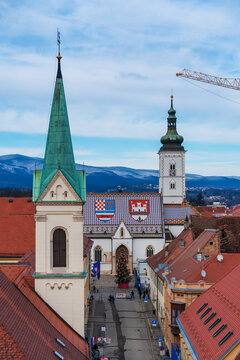 Decorated Christmas tree in front of St. Mark&rsquo;s Church with its famous colorful tiled roof in Zagreb. Festive winter scene in the historic city center