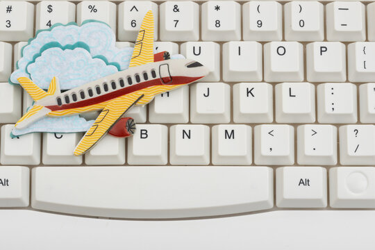 Airplane on a white computer keyboard for booking a flight online