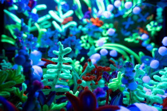 Colorful glowing abstract fantasy garden made from handcrafted shapes under ultraviolet lighting creating vibrant surreal background artwork