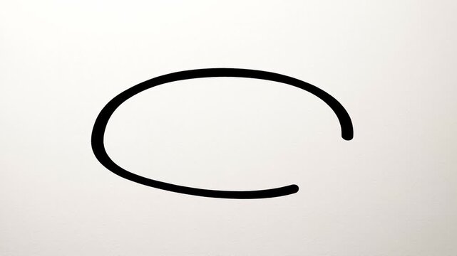 Time lapse still shot of ink oval being sketched and progressively revealed on white paper surface in studio close up view of pen tracing circular stroke