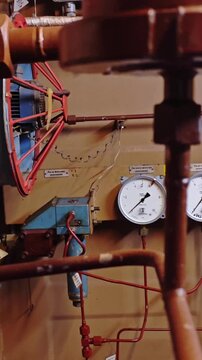 Pressure meters and fittings inspected. Inspection of brass fittings and pressure gauges in facilities. Assessment of copper pipe circuitry and gauge calibration in industrial setting equipment