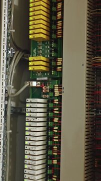 Industrial power panel. Electrical control unit with relays. Closeup of power distribution with yellow relays. Detailed view of electrical distribution rack with terminal connections