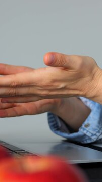 Hands typing on computer keyboard. Hands in denim sleeve actively engaging with keyboard and gestures. Casual workspace scene with hands typing and making gestures during creative discussion