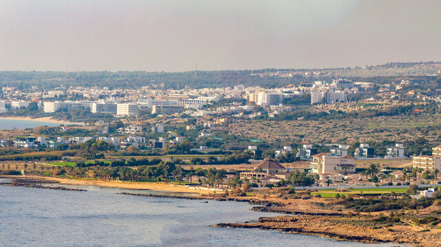 Panoramic view of Ayia Napa coastal town with hotels and residential villas from a high viewpoint at Cape Greco area during sunny winter low season.