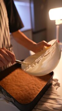 Closeup of dessert construction highlighting smooth filling application
