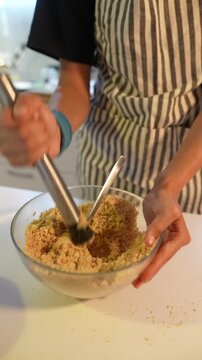 Closeup of hands mashing crumb mix in vibrant cooking environment