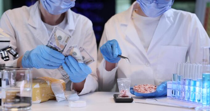 Expert counts money over drugs and colleague puts pills into package on scales in lab. Female forensic scientists work on narcotic case in laboratory