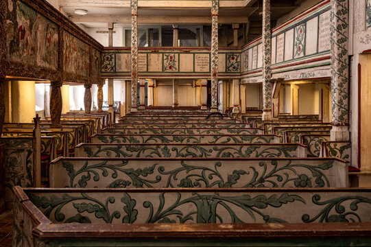 Painted wooden pews and gallery inside a historic church in Massen, Germany