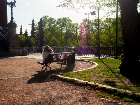 Woman Sitting on a Bench in Evening Sunlight