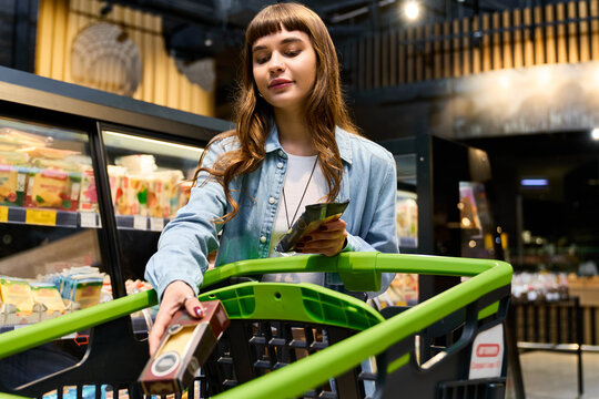 Young woman shops stylishly in supermarket, exploring vibrant grocery options effortlessly