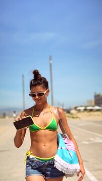 Woman Walking by the Coast and Checking Her Smartphone