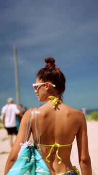 Woman walking toward a sunny beach
