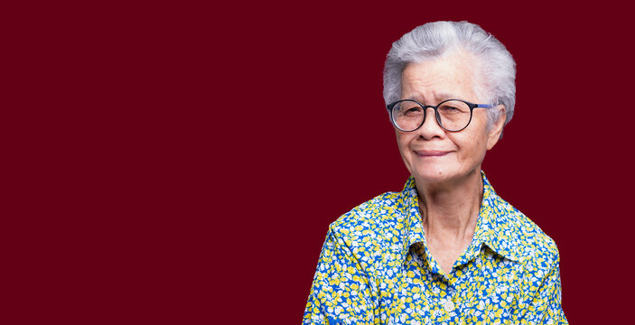 Smiling senior woman portrait on red background
