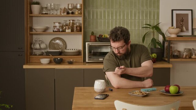 Medium shot of adult Caucasian man with diabetes sitting at table and injecting insulin into arm. Footage perfect for diabetes awareness campaigns and healthcare marketing