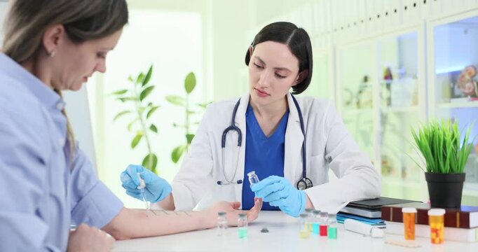 Focused doctor conducts allergy test applying substances onto patient skin in clinic. Woman visits physician to define cause of disease in hospital