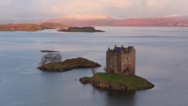 Dramatic sunrise lighting up castle stalker in scotland