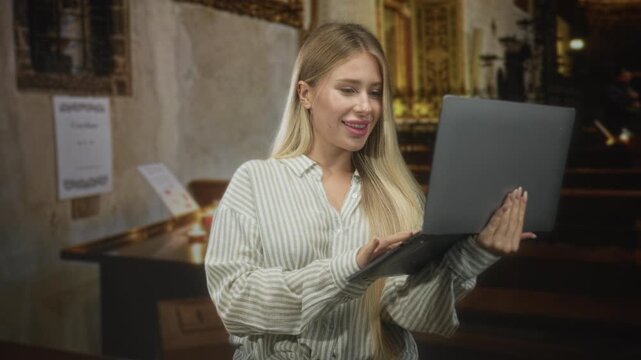 Woman holding laptop and typing with both hands inside ornate church building, smiling and engaged; focused calm productivity.