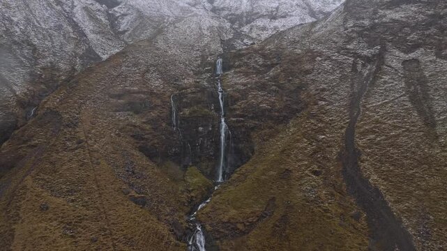Drone flying backward revealing waterfall in glen coe, scotland