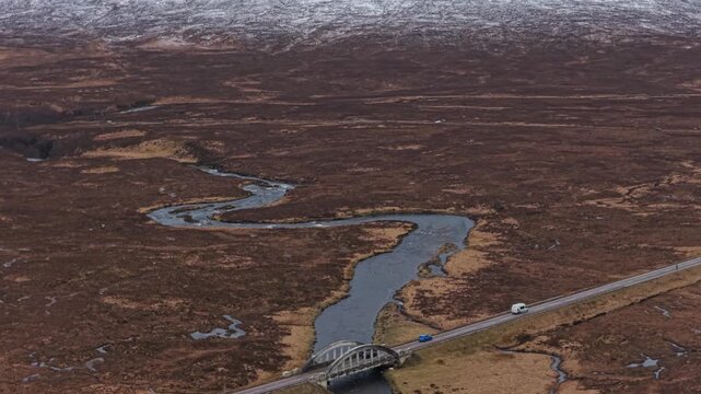 Aerial view of river etive bridge and snow capped mountains