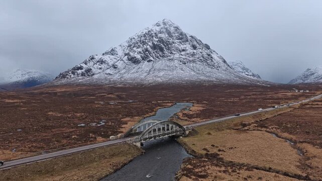 Cars driving over river etive bridge towards buachaille etive mor mountain