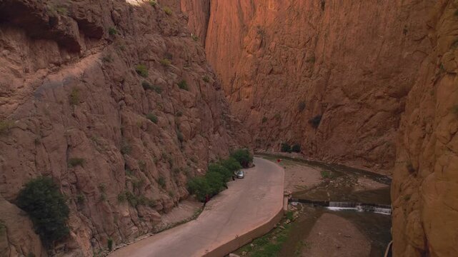 Todra Gorge near Tinghir, Dr&acirc;a Tafilalet, Morocco, featuring steep canyon cliffs carved by the Todgha River within the eastern High Atlas foothills, drone parallax ascent and pullback shot.