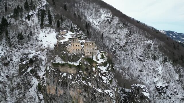 Aerial drone shot of historical Kustul Monastery covered in snow during winter season in Trabzon, Turkey.