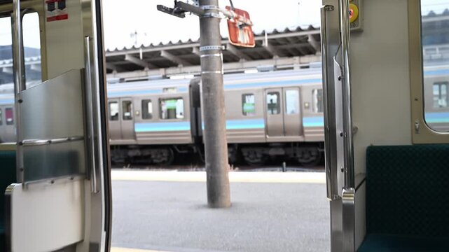ローカル線の車内に設置された半自動ドアの開閉ボタン（押しボタン）のクローズアップ