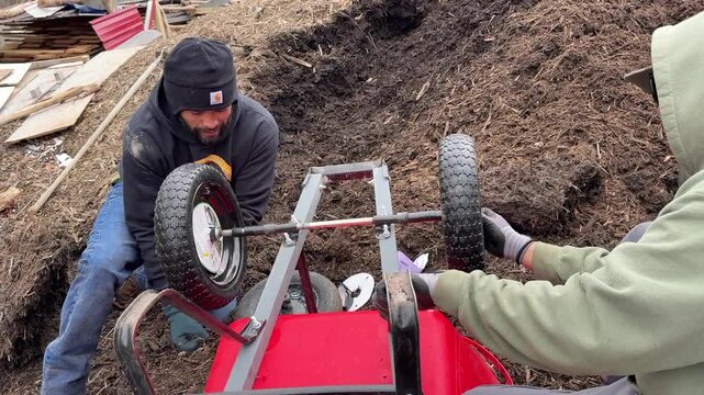 Replacing wheel barrow tires while doing landscape job