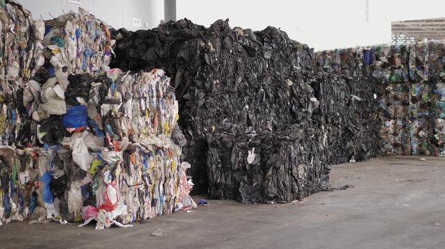 Garbage Recycling Factory, Plastic cubes for recycle Plant, Bales of pressed boxes, rubbish warehouse collection. Preparation of recyclables for recycling, Plastic city garbage.