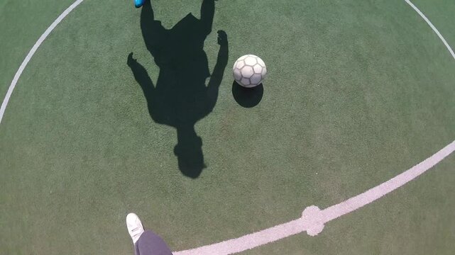 Football player skillfully dribbling ball on green turf field, showcasing dynamic movement and control, emphasizing athleticism and technique in a continuous action sequence